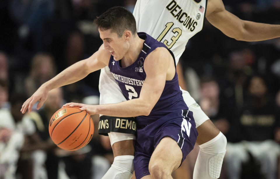 Northwestern guard Ryan Greer (2) dribbles around the defense of Wake Forest forward Dallas Walton (13) in the first half of an NCAA college basketball game on Tuesday, Nov. 30, 2021, at the Joel Coliseum in Winston-Salem, N.C. (Allison Lee Isley/The Winston-Salem Journal via AP)