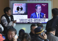 People watch a TV screen showing the live broadcast of South Korean President Moon Jae-in's speech on the economy given before the parliament, at the Seoul Railway Station in Seoul, South Korea, Thursday, Nov. 1, 2018. Moon says North Korean leader Kim Jong Un will "soon" visit Seoul. The signs read" Kim Jong Un will "soon" visit Seoul." (AP Photo/Ahn Young-joon)