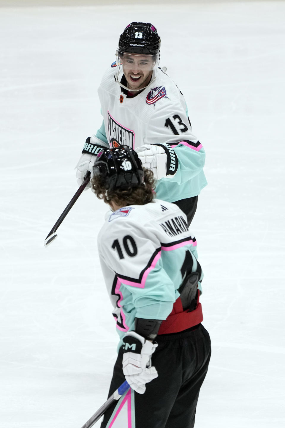 Metropolitan Division's Johnny Gaudreau, of the Columbus Blue Jackets (13) celebrates with Metropolitan Division's Artemi Panarin of the New York Rangers (10) after scoring a goal during the NHL All Star hockey game, Saturday, Feb. 4, 2023, in Sunrise, Fla. (AP Photo/Marta Lavandier)