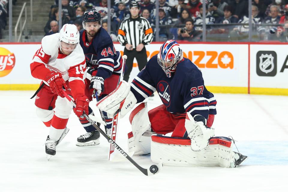 Detroit Red Wings forward Jakub Vrana chases the rebound in front of Winnipeg Jets goalie Connor Hellebuyck during the first period at Canada Life Centre, April 6, 2022 in Winnipeg, Manitoba, Canada.