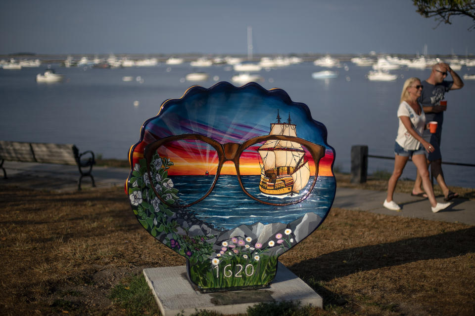 Pedestrians walk past a commemorative shell decorated to celebrate the 400th anniversary of the arrival of the Pilgrims in 1620 on the Mayflower, in Plymouth, Mass., Wednesday, Aug. 12, 2020. Disease introduced by traders and settlers, either by happenstance or intention, played an important role in the conquest of Native peoples. And that inconvenient fact, well known to the Natives' descendants, is contrary to the traditional narrative of the "New World." (AP Photo/David Goldman)