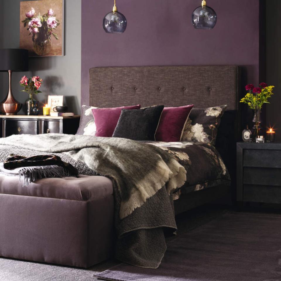 Purple bedroom, double bed with large brown headboard, pendants, dark bedside tables.