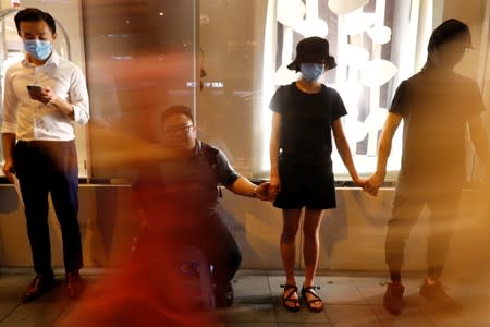 Protesters hold hands to form a human chain during a rally to call for political reforms in Hong Kong's Central district