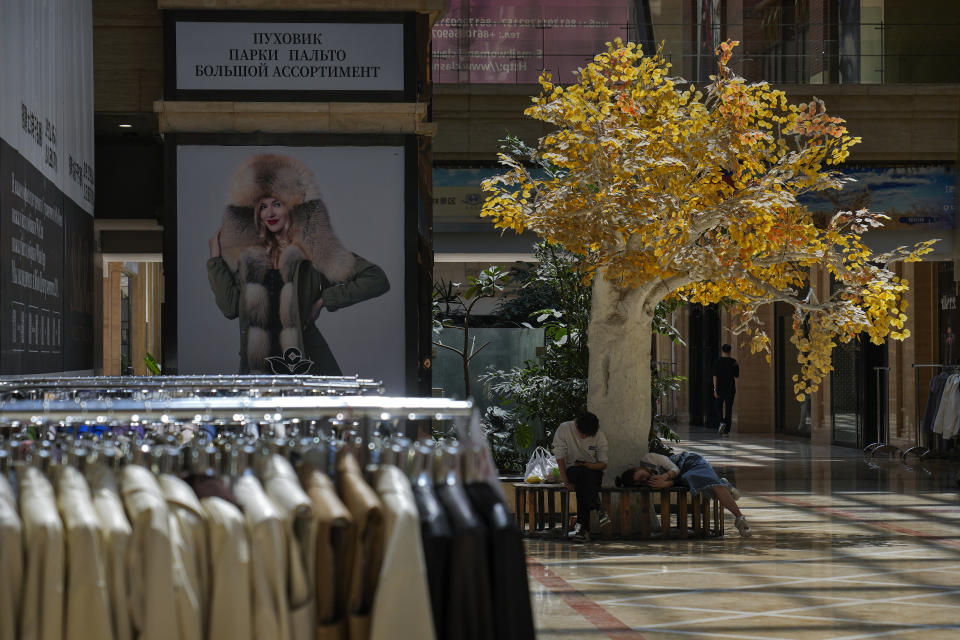 Residents rest under a fake golden leafs tree at Ritan International Trade Center in Beijing on Wednesday, May 15, 2024. Data released on Friday, May 17 showed housing prices in China slumped for the first four months of the year, although factory output rose nearly 7%, as the country prepares to announce fresh measures to reinvigorate its ailing property industry. (AP Photo/Andy Wong)