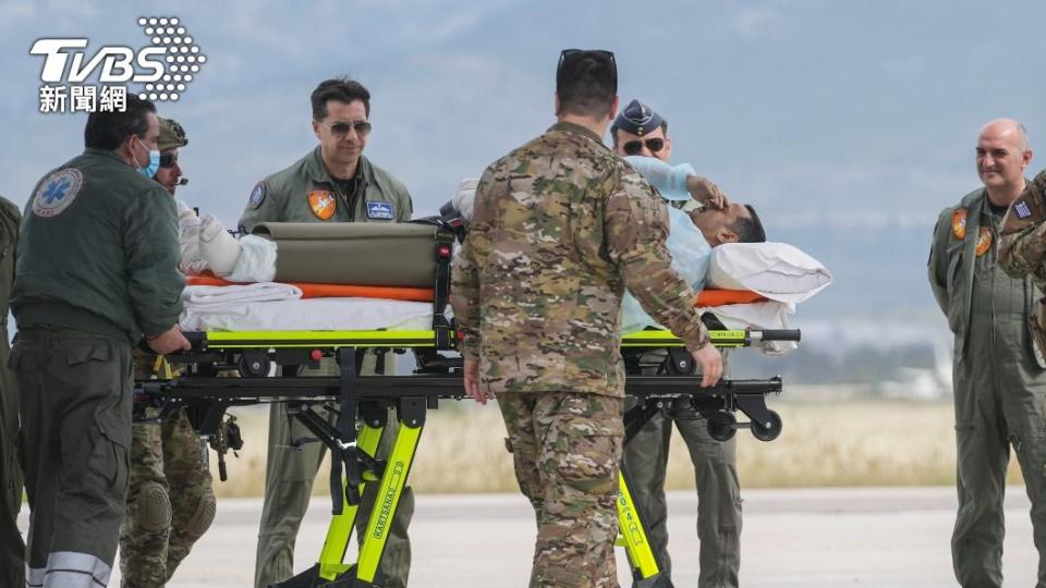 希臘空軍及醫護人員將傷患送下軍機。（圖／達志影像美聯社）