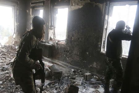 Rebel fighters take positions inside a damaged building during clashes with forces loyal to Syria's President Bashar al-Assad who are stationed in Aleppo's historic citadel December 7, 2014. REUTERS/Abdalrhman Ismail