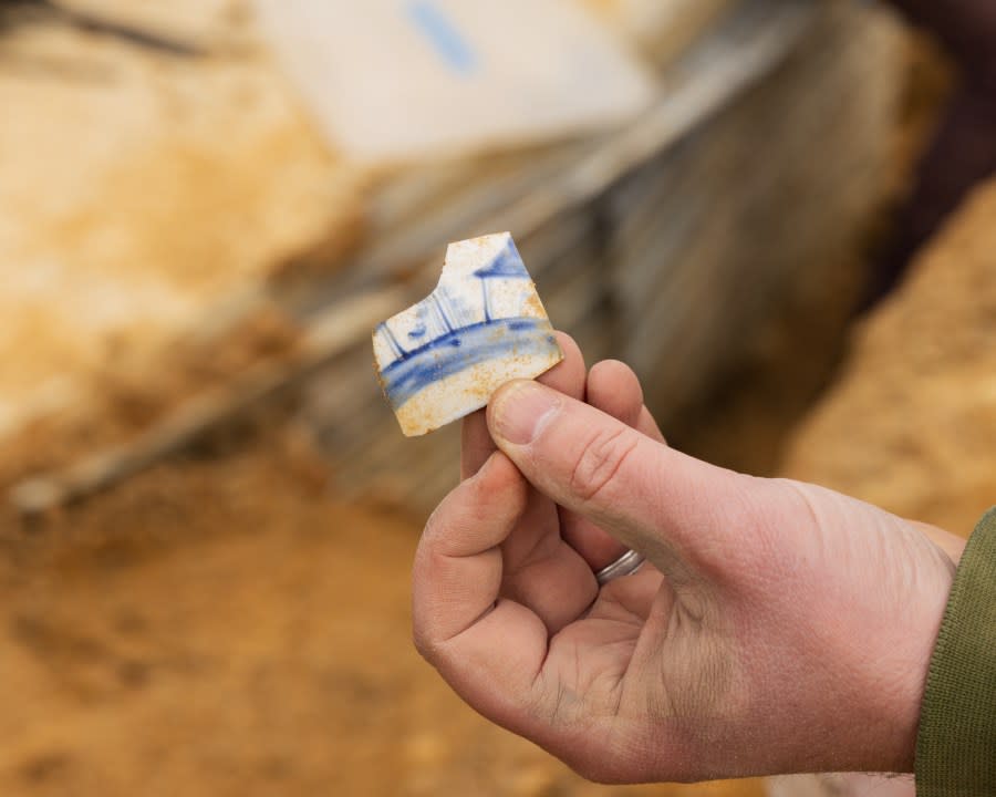 Colonial Williamsburg Archaeology staff investigates remains of 18th Century house at future Campbell Archaeology Center site. Piece of porcelain found at the site.