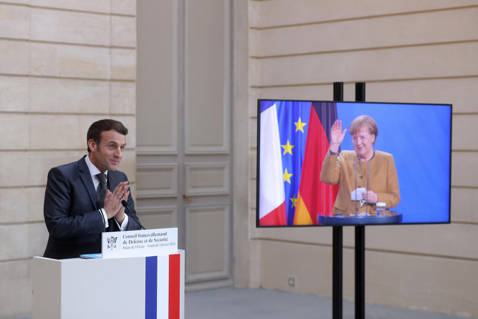 German Chancellor Angela Merkel waves goodbye to French President Emmanuel Macron after a German-French Security Council video conference Friday, Feb. 5, 2021 at the Elysee Palace in Paris. (AP Photo/Thibault Camus, Pool)