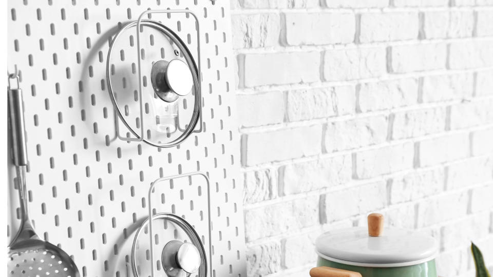 Pot lids on white pegboard