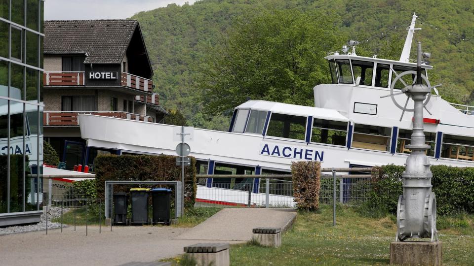 Das Fahrgastschiff "Aachen" liegt am Ufer des Rursees vor einem Hotel auf dem Trockenen