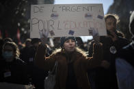 A student chants slogans while holding a sign that reads "money for education" during a demonstration in Marseille, southern France, Tuesday Jan. 26, 2021. Teachers and university students marched together in protests or went on strike Tuesday around France to demand more government support amid the pandemic. (AP Photo/Daniel Cole)