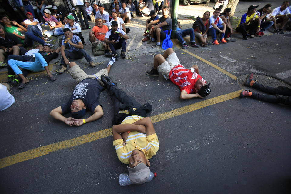 Scores of Central American migrants, representing the thousands participating in a caravan trying to reach the U.S. border, rest in front of the office of the United Nation's human rights body, after undertaking an hours-long march to demand buses, in Mexico City, Thursday, Nov. 8, 2018. Members of the caravan which has stopped in Mexico City demanded buses to take them to the U.S. border, saying it is too cold and dangerous to continue walking and hitchhiking.(AP Photo/Rebecca Blackwell)