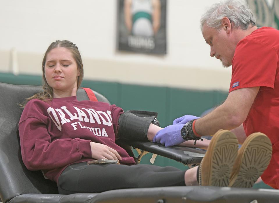 Tenth-grader Grace Speelman's expression gives a faint hint of pain as Werner Horner draws blood during the blood drive Thursday morning at Madison Comprehensive High School.