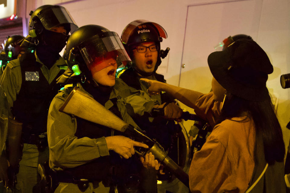 A resident confronts riot police outside of the Prince Edward metro station in Hong Kong, Saturday, Nov. 30, 2019. Hundreds of silver-haired activists joined young Hong Kong protesters for a unity rally Saturday, vowing that their monthslong movement will not fade away until there is greater democracy in the Chinese territory. (AP Photo/Ng Han Guan)