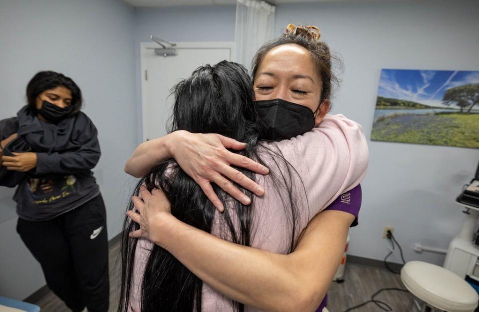 OC, the older sister of MC, hugs Tien in gratitude, following her sister’s appointment (Reuters)