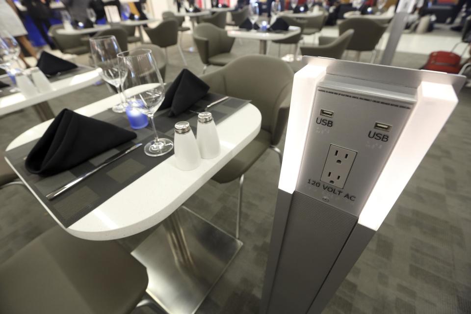 A battery recharge station is positioned next to a a table set up for dining in the Delta airlines Sky club in terminal 4 at JFK airport, Friday, May 24, 2013 in New York. Delta opened its new $1.4 billion terminal, strengthening its hand in the battle for the lucrative New York travel market. The expanded concourse offers sweeping views of the airport, upscale food and shopping options and increased seating. It replaces a decrepit terminal built by Pan Am in 1960 that was an embarrassing way to welcome millions of visitors to the United States. (AP Photo/Mary Altaffer)