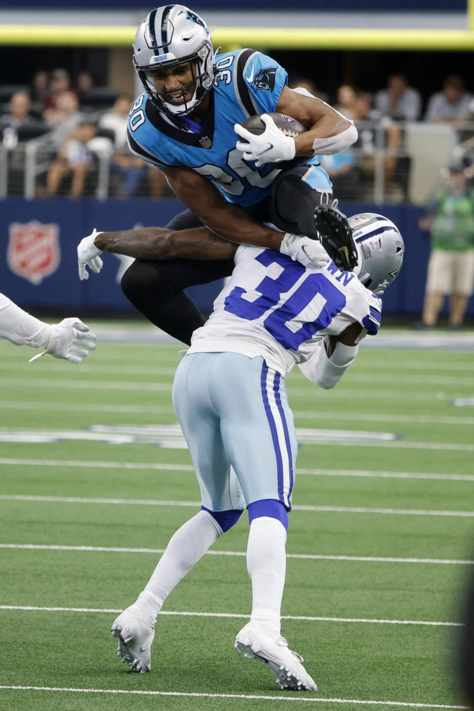 Carolina Panthers running back Chuba Hubbard (30) is tackled as as he attempts to leap past Dallas Cowboys cornerback Anthony Brown (30) in the first half of a NFL football game in Arlington, Texas, Sunday, Oct. 3, 2021. (AP Photo/Michael Ainsworth)