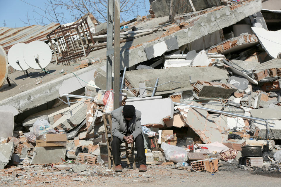 Seho Uyan, who survived a deadly earthquake, but lost his four relatives, sits in front of a collapsed building in Adiyaman, Turkey February 11, 2023. REUTERS/Sertac Kayar     TPX IMAGES OF THE DAY