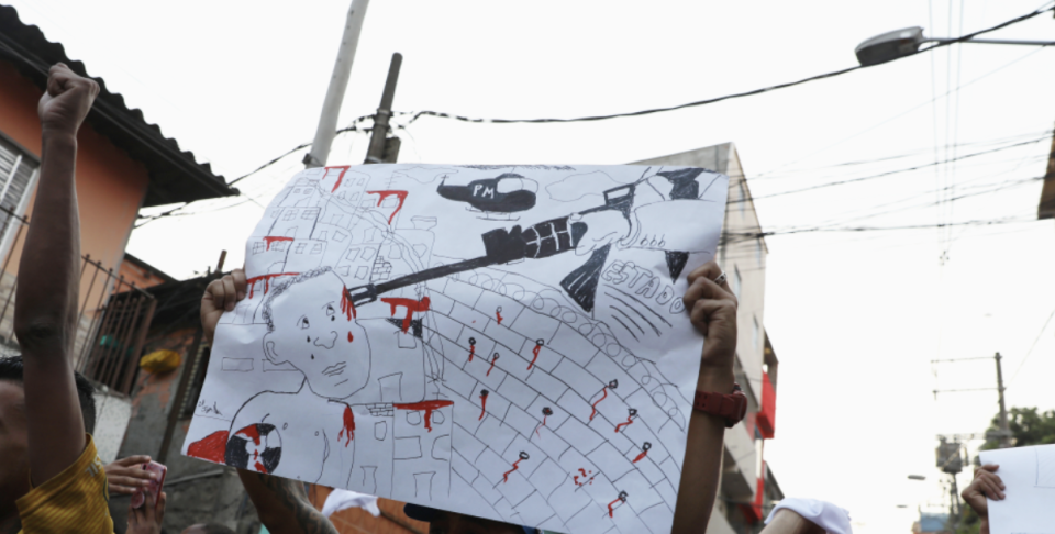 Cartaz exibido em protesto em Parais&#xf3;polis ap&#xf3;s chacina no local em 2019: jovens da comunidade querem fiscalizar quem decide as leis atrav&#xe9;s do voto (REUTERS/Amanda Perobelli)