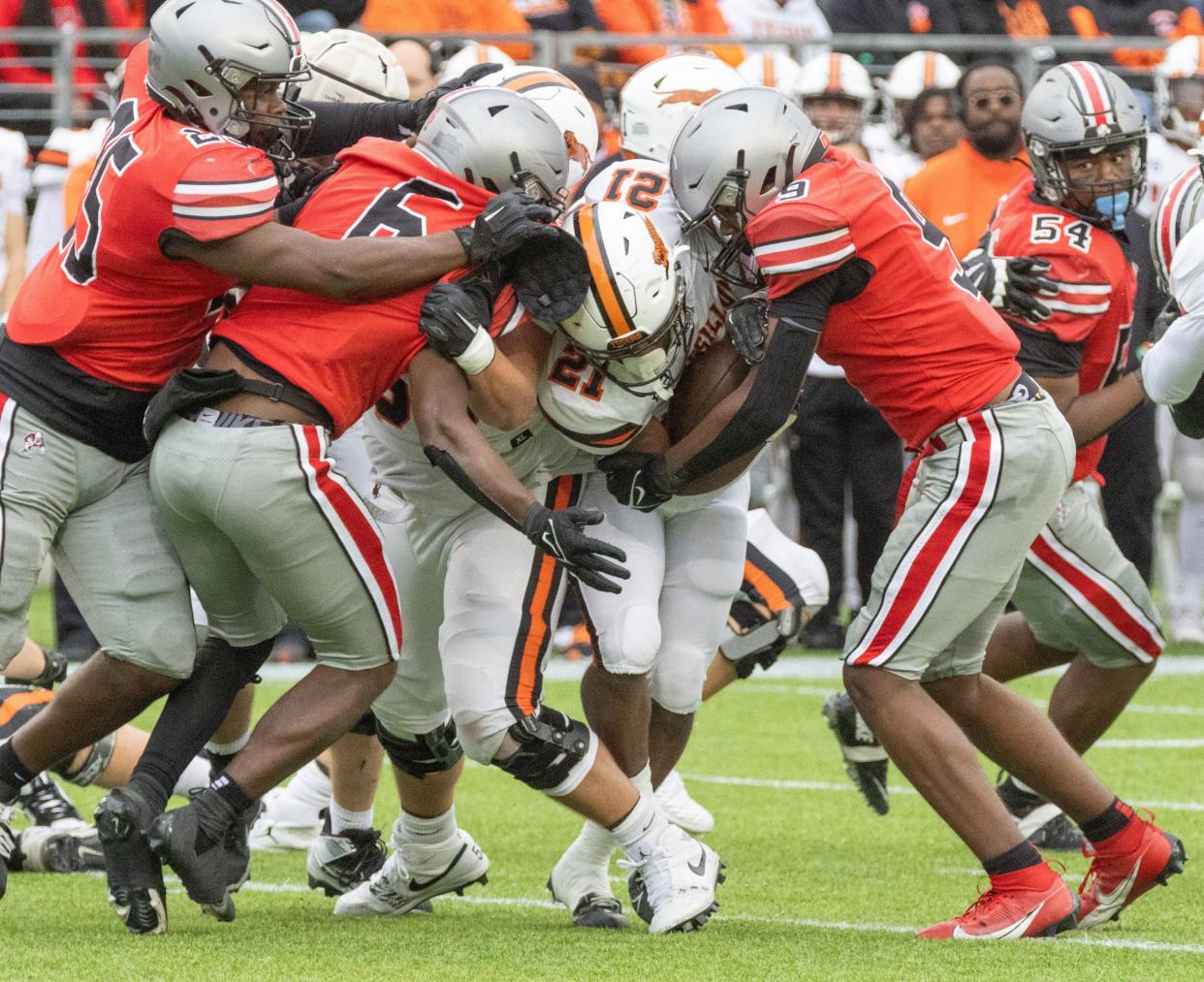 McKinley’s defensive players Braylon Minor (25), Shaukeer Hatcher (6), and Dante McClellan (9) swarm Massillon’s Ja’Meir Gamble on Saturday, Oct. 21, 2023.