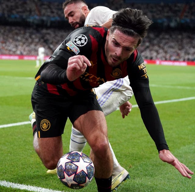 Manchester City&#39;s Jack Grealish is shoved into the advertising hoardings by Real Madrid&#39;s Dani Carvajal, rear