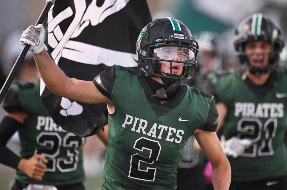 Reedley’s Malachi Rios carries a pirate flag into the stadium at the start of the game against Roosevelt, his last game before undergoing chemotherapy for a second time Friday night, Aug. 25, 2023 in Reedley.