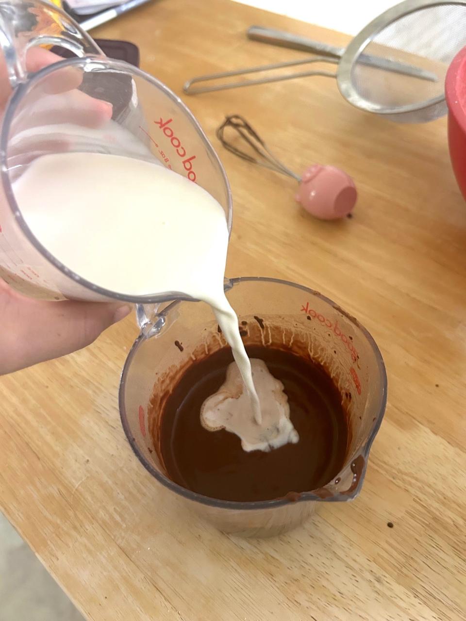 Adding half and half to chocolate mixture for Ina Garten's chocolate cake with mocha frosting