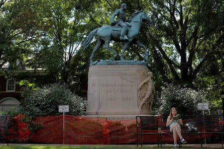 A young woman reads under a statue of Civil War Confederate General Thomas "Stonewall" Jackson in a park, ahead the one-year anniversary of the fatal white-nationalist rally, in Charlottesville, Virginia, U.S., August 1, 2018. REUTERS/Brian Snyder