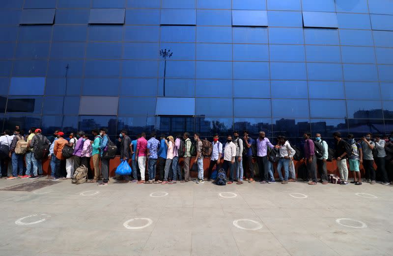 People wait in a line to enter the Lokmanya Tilak Terminus railway station, amid the spread of the coronavirus disease (COVID-19) in Mumbai