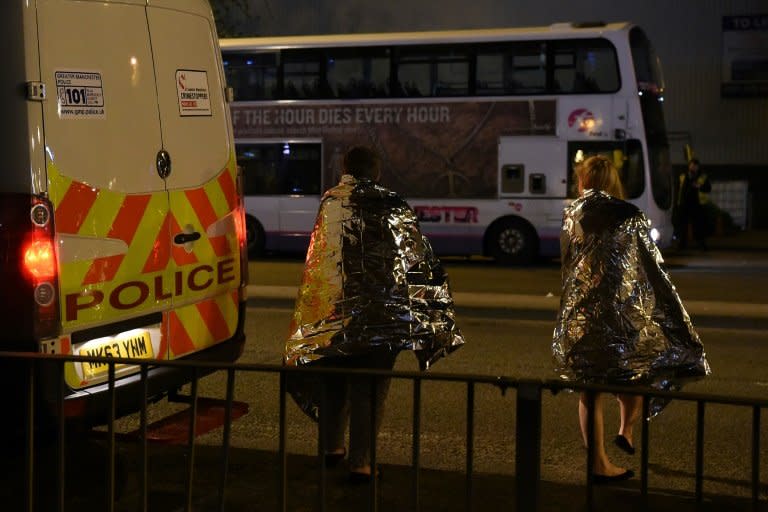 Concert goers wait to be picked up after a suspected terror attack during a pop concert by Ariana Grande in the northern English city of Manchester