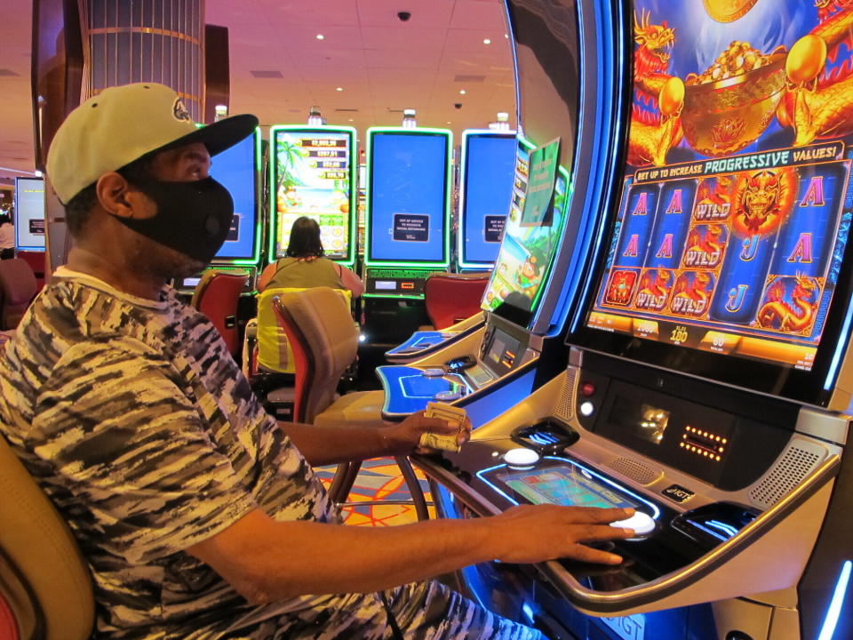 A gambler plays a slot machine at the Hard Rock Casino in Atlantic City N.J. on July 2, 2020, the day the casino reopened amid the coronavirus outbreak. New Jersey's casinos and horse tracks won $264.5 million in July, a figure that was down nearly 21% from a year ago, but one the gambling houses will gladly take after months of inactivity. (AP Photo/Wayne Parry)