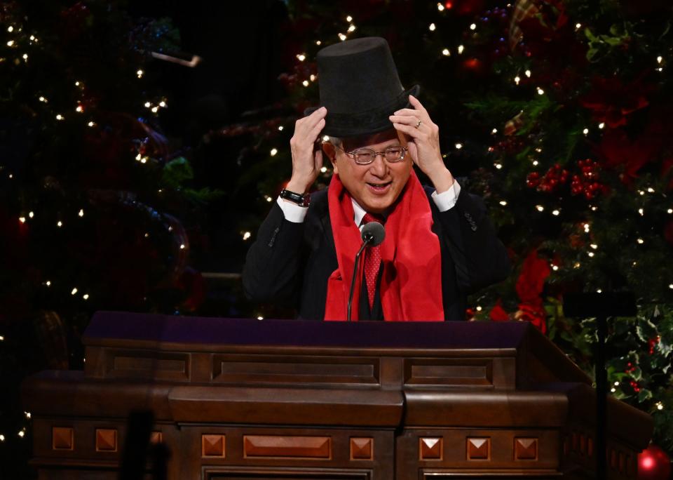 Elder Gerrit W. Gong places a top hat on his head during the 2023 First Presidency Christmas Devotional.