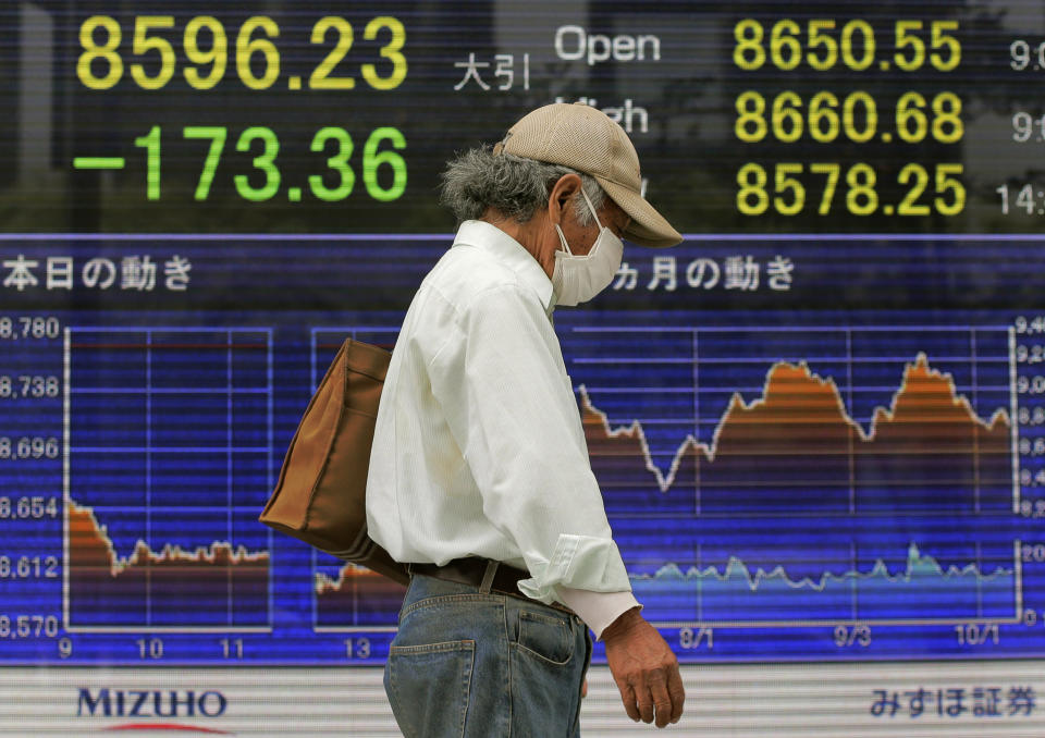 A man walks in front of the electronic stock board of a securities firm showing Japan's Nikkei 225 index falling 173.36 points to 8596.23 in Tokyo, Wednesday, Oct. 10, 2012. Worries about Europe's debt crisis, signs of weak global growth and expectations of lower U.S. corporate earnings sent most Asian stock markets down Wednesday. (AP Photo/Itsuo Inouye)