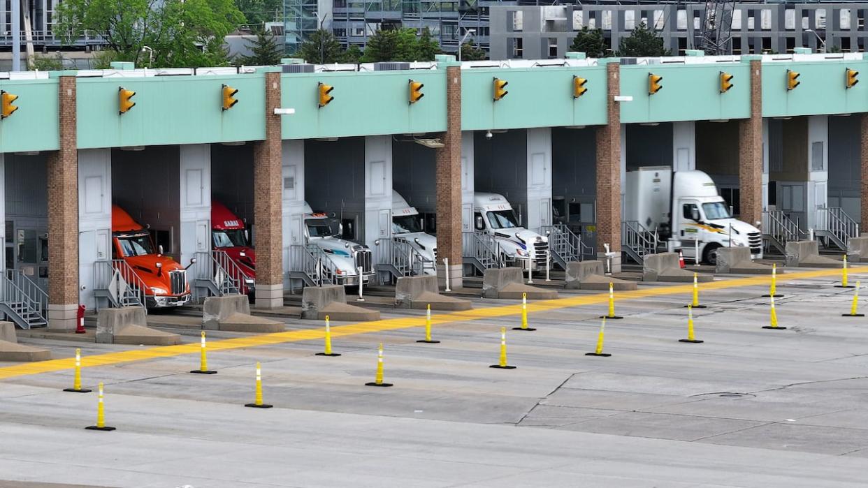 Trucks are shown going through customs at the Ambassador Bridge. The unions representing over 9,000 border workers and CBSA have reached a tentative agreement, which means job action that could have proceeded later this week has been averted. (Patrick Morrell/CBC - image credit)