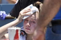 A young fan holds ice to her head after being hit with a foul ball hit by Los Angeles Dodgers' Cody Bellinger during the first inning of a baseball game against the Colorado Rockies, Sunday, June 23, 2019, in Los Angeles. (AP Photo/Mark J. Terrill)