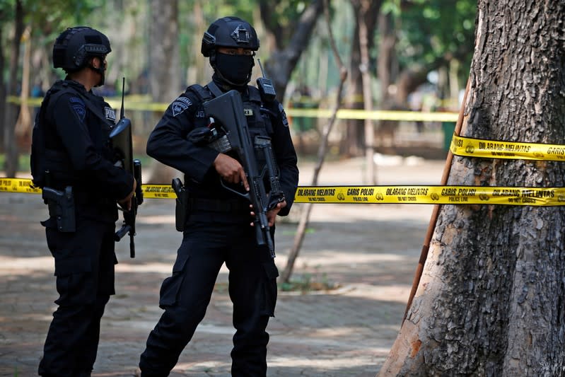 Armed police officers stand guard following a blast at National Monument (Monas) complex in Jakarta