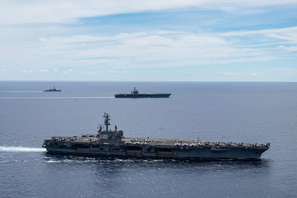 In this July 6, 2020, photo provided by the U.S. Navy, the USS Ronald Reagan (CVN 76, front) and USS Nimitz (CVN 68, rear) Carrier Strike Groups sail together in formation, in the South China Sea