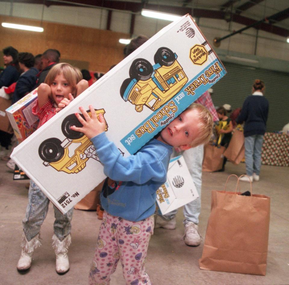 Kristina Young, 4, has her hands full as she prepares to leave with the presents she picked up at the J.P. Hall Sr. Children's Charities toy giveaway at the Clay County Agricultural Fairgrounds in 1998.