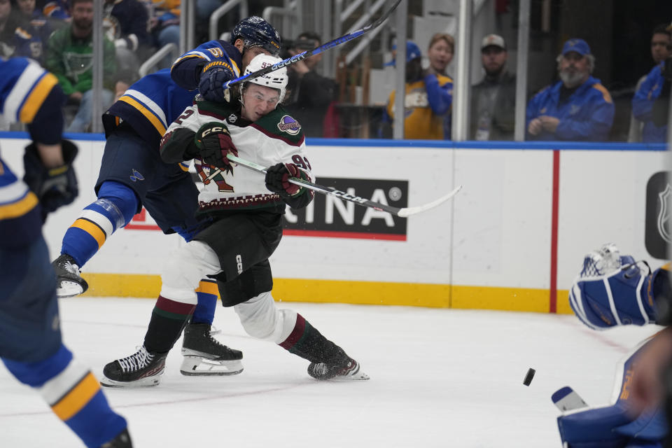 Arizona Coyotes' Logan Cooley (92) tries to get off a shot as St. Louis Blues' Marco Scandella defends during the third period of an NHL hockey game Thursday, Oct. 19, 2023, in St. Louis. (AP Photo/Jeff Roberson)