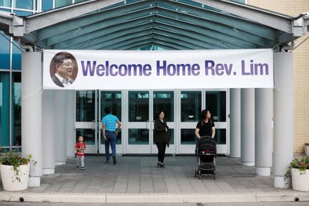 People walk under a welcome home sign for Pastor Hyeon Soo Lim, who returned to Canada from North Korea after the DPRK released Lim on August 9 after being held for 31 months, at the Light Presbyterian Church, in Mississauga, Ontario, Canada August 12, 2017. REUTERS/Mark Blinch