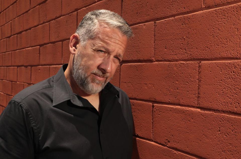 Man standing in front of a brick wall