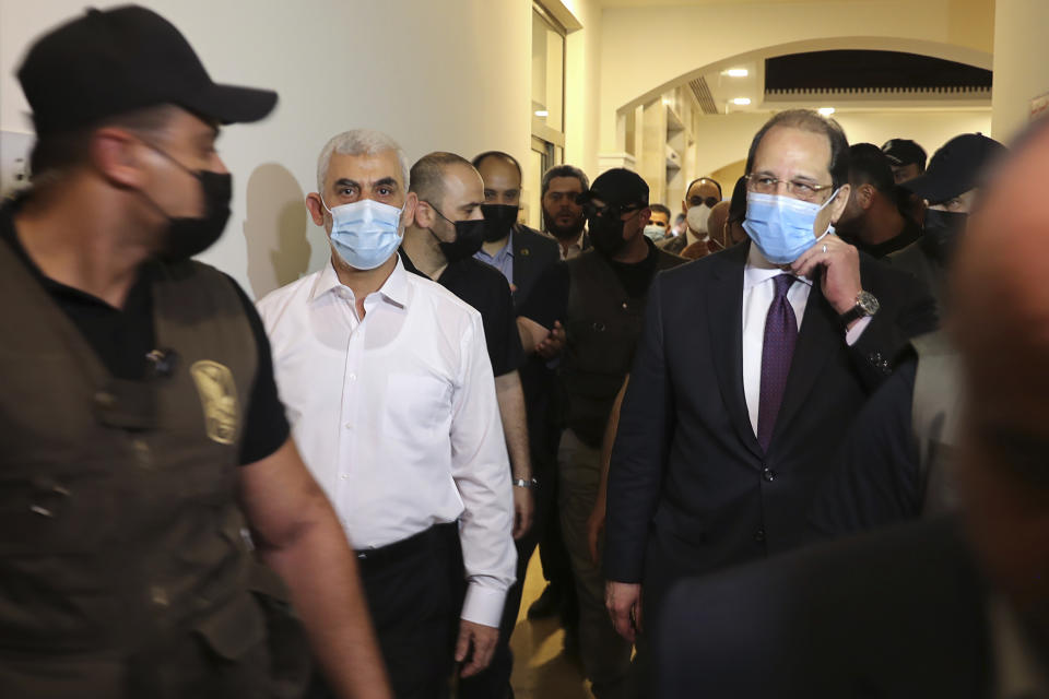 Yehiyeh Sinwar, second left, the top Hamas leader in Gaza, and the head of the Egyptian General Intelligence Abbas Kamel, right, walk as they meet in Gaza Monday, May 31, 2021. (Mohammed Salem/Pool Photo via AP)