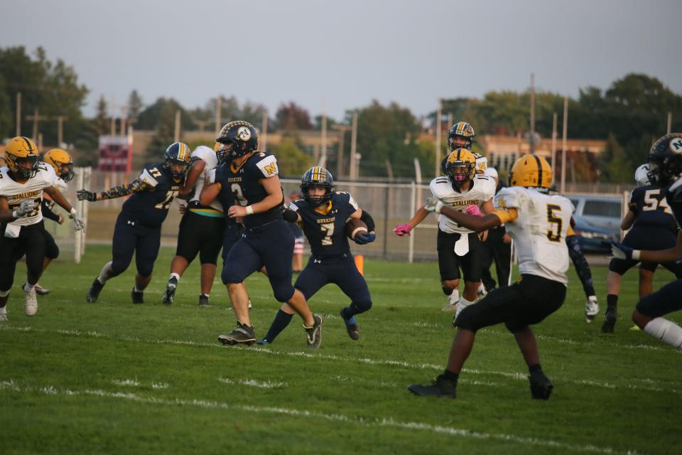 Port Huron Northern running back Hayden Prone runs through defenders during the Huskies' 43-8 win over Sterling Heights at Memorial Stadium in Port Huron on Friday.
