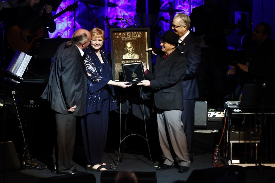 Rose Drake y John Drake reciben la medalla para Pete Drake de manos de Charlie McCall y Kyle Young, CEO del Museo y Salón de la Fama de la Música Country, el domingo 1 de mayo de 2022 en Nashville, Tennessee. (Foto por Wade Payne/Invision/AP)