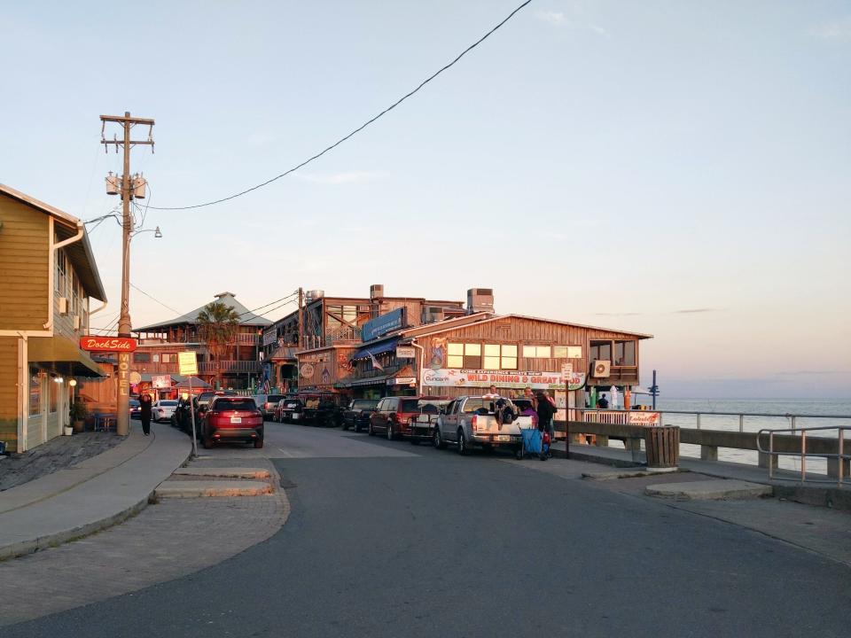 A quiet street next to the beach with a few businesses.