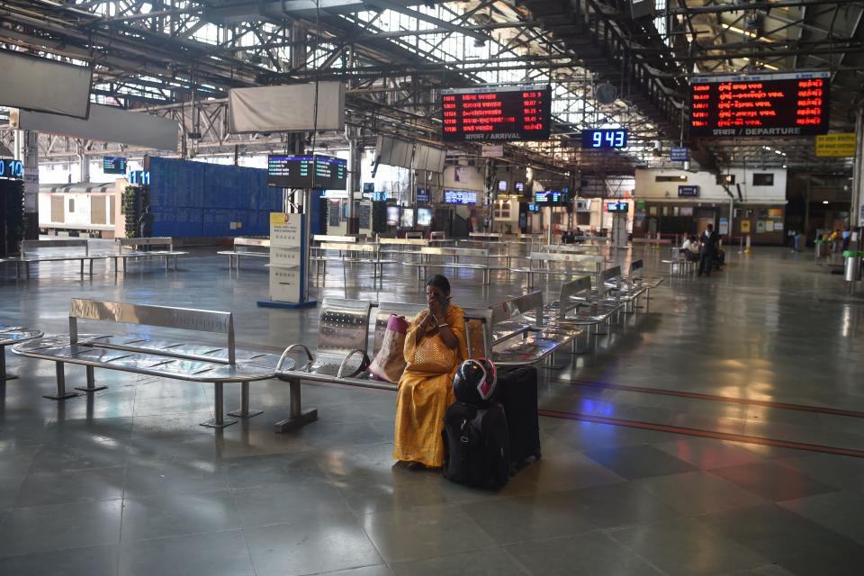 A commuter sits at Chhatrapati Shivaji Maharaj railway terminus during a one-day Janata (civil) curfew imposed amid concerns over the spread of the COVID-19 novel coronavirus, in Mumbai on March 22, 2020. (Photo by Punit PARANJPE / AFP) (Photo by PUNIT PARANJPE/AFP via Getty Images)