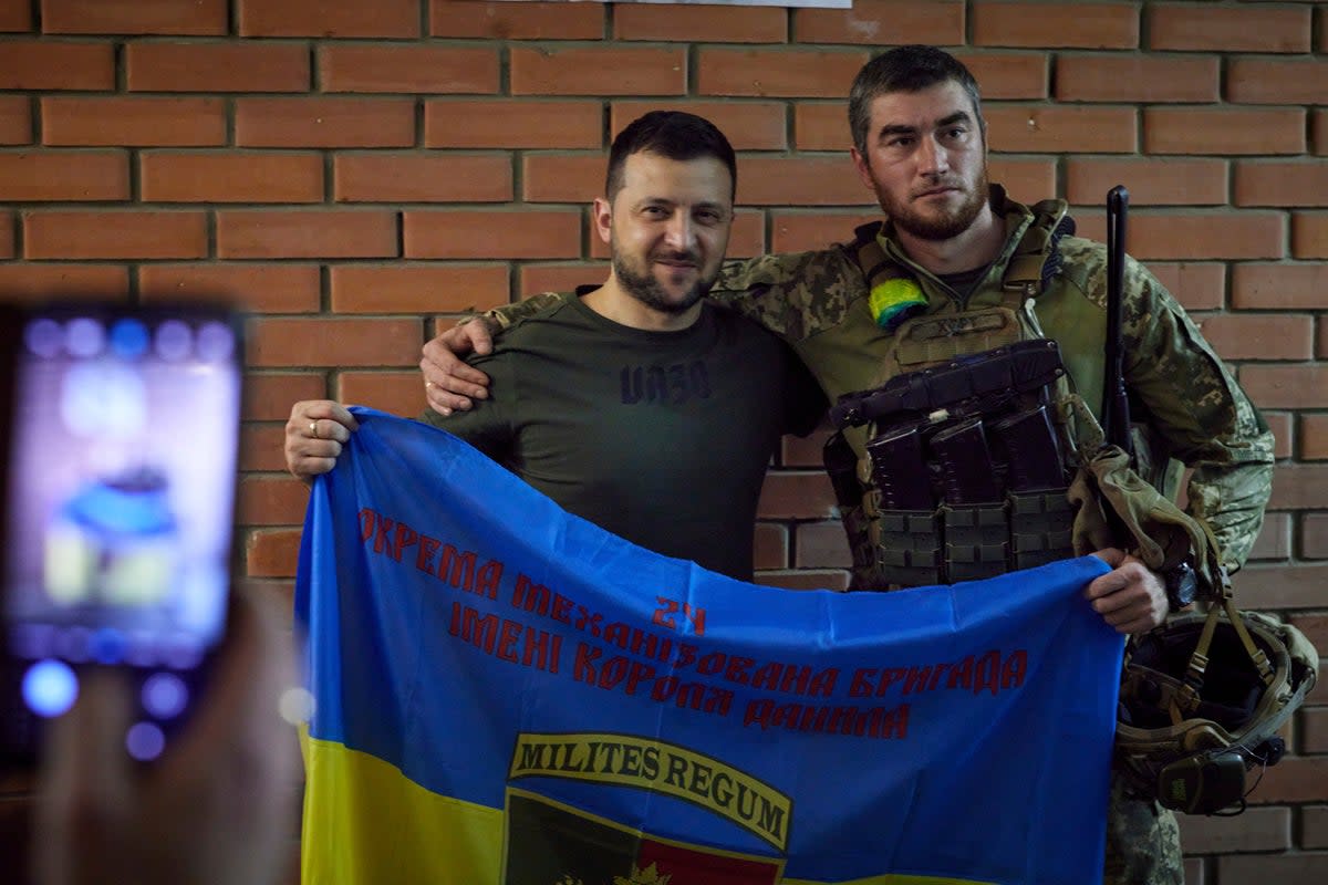 President Volodymyr Zelenskyy, left, poses for a photo with serviceman close to the front line in Donetsk region (AP)