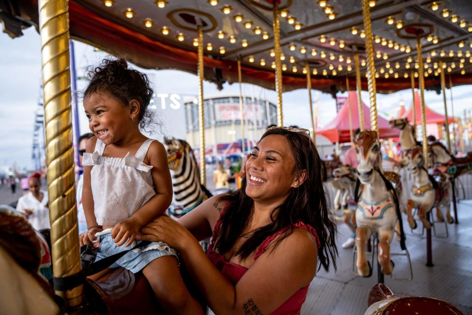 Daya L., 2, and her mother Larrisa L., ride a carousel at the Arizona State Fair in Phoenix on Sept. 22, 2023.