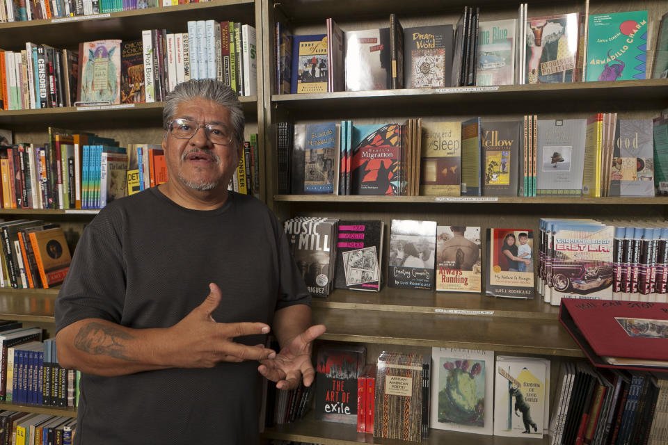 FILE - In this file photo taken Monday, Sept. 12, 2011, writer and activist Luis J. Rodriguez poses for a photo at his independent bookstore and community center "Tia Chucha" in Los Angeles. Rodriguez's collection of essays released Jan. 28, 2020 is among the books Latinos are recommending via social media amid the controversy surrounding the novel, "American Dirt." (AP Photo/Damian Dovarganes,File)