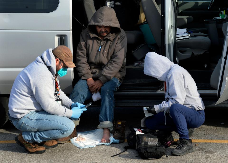 Dr. Pete Cathcart and medical assistant Brandy Hampton talk to Mike Lopez about his frost bitten toes on Wednesday, January 12, 2022, near a small homeless encampment in South Nashville